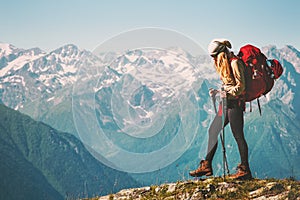 Girl Traveler hiking with backpack at rocky mountains photo