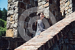 Girl traveler visiting old medieval castle walk