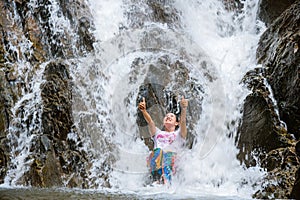 Girl traveling waterfall on holiday. The girl who is enjoying playing the waterfall happily. travel nature, Travel relax, travel