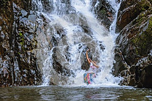 Girl traveling waterfall on holiday. The girl who is enjoying playing the waterfall happily. travel nature, Travel relax, travel