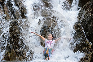 Girl traveling waterfall on holiday. The girl who is enjoying playing the waterfall happily. travel nature, Travel relax, travel