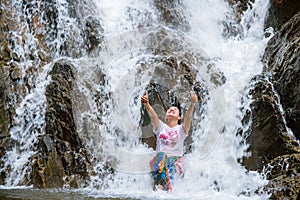 Girl traveling waterfall on holiday. The girl who is enjoying playing the waterfall happily. travel nature, Travel relax, travel