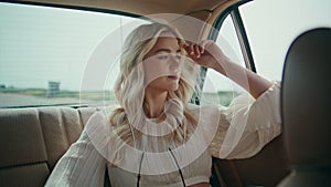 Girl travelling car backseat looking window on road close up. Woman riding auto.