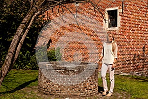 Girl tree brick stone wall well, Groot Begijnhof, Leuven, Belgium