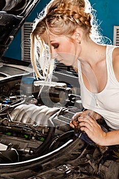 Girl tries to repair broken car