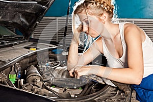 Girl tries to repair broken car