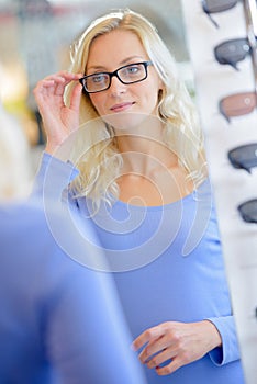 Girl trying on glasses with black rims