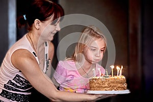 Girl trying to blow out candles on birthday cake
