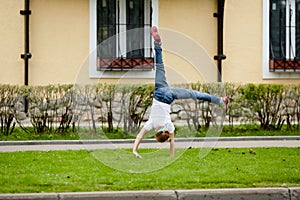 Girl turns cartwheel on grassy lawn in front of photo