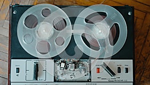 The girl turns on the old reel-to-reel tape recorder and playback is in progress