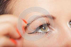 Girl tweezing eyebrows closeup