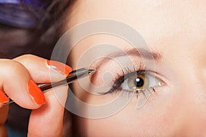 Girl tweezing eyebrows closeup