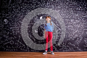 Girl with two braids, big blackboard with mathematical symbols