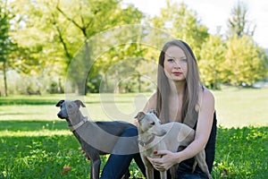 Girl with two greyhounds in the park