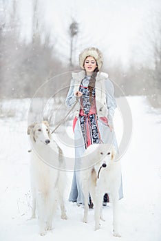 Girl with two greyhounds walking in winter