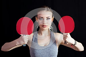 Girl with two rackets for playing table tennis.