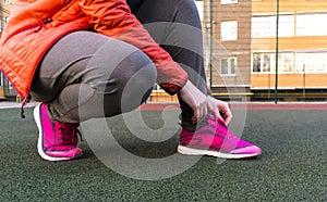 girl tying shoelaces. Woman tying her sport shoes. fitness concept.