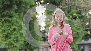 Girl typing text message on smartphone or hands using mobile phone in the park.