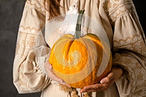 A girl in a Ukrainian dress holds a pumpkin, a symbol of rejection of a suitor photo