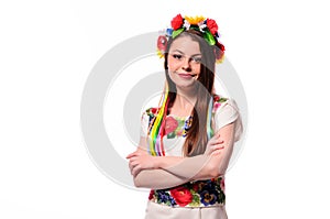 Girl in Ukrainian national traditional costume holding her flower chaplet - isolated on white