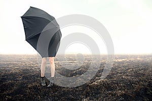 Girl with umbrella on black field photo