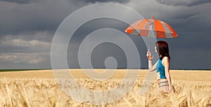 Girl with umbrella at field.