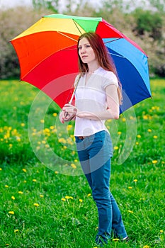 Girl with umbrella in a green meadow