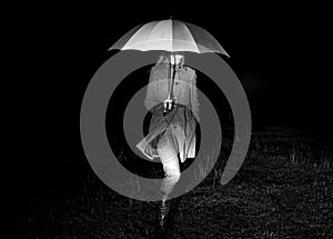 Girl with umbrella at night in lights.