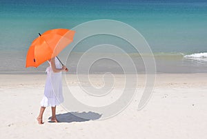 Girl with an umbrella on the sandy beach