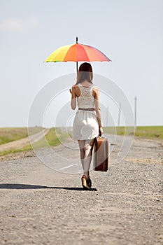 Girl with umbrella and suitcase