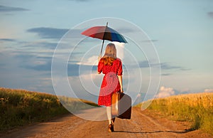 Girl with umbrella and suitcase