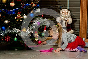 Girl under Christmas tree cleaning needles