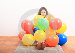 Girl under inflating balloons