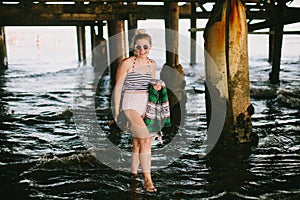 Girl under pier on beach
