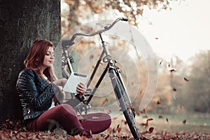 Girl under tree with bike.