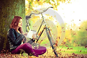 Girl under tree with bike.