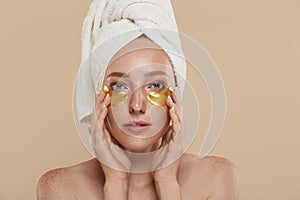 Girl with undereye patches and towel on head photo