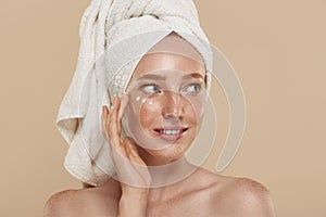 Girl with undereye patches and towel on head photo