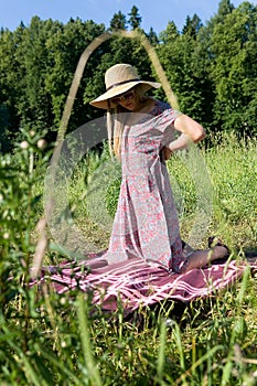 A girl undresses in a summer park.