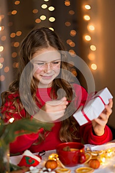 Girl unfolds a Christmas gift