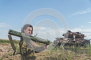 Girl in uniform with a Bazooka on the background of a broken tan