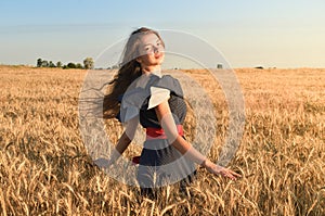 The girl with the unraveling hair spins in the field