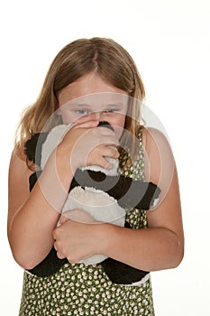 Girl is upset and gives her bear a cuddle