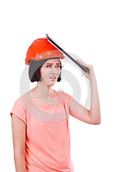 A girl is upset sticking a writing pad for papers to a hard hat on a white isolated background