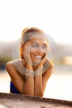 Girl on an upside down rowboat smiling