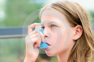 Girl uses an inhaler during an asthma attack