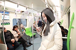 Girl uses mobile phone while travel by subway,Woman using her cell phone in Subway