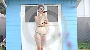 Girl uses a phone near a beach house
