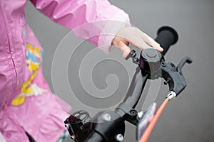The girl uses a signal on a child`s Bicycle