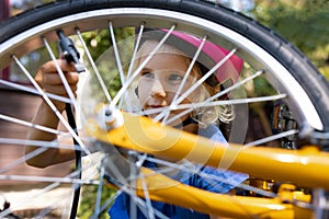 girl using air pump to inflate bicycle tire outdoors. bike maintenance